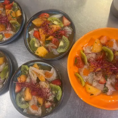 Cinq bols de ceviche, agrumes, kiwi et herbes fraîches