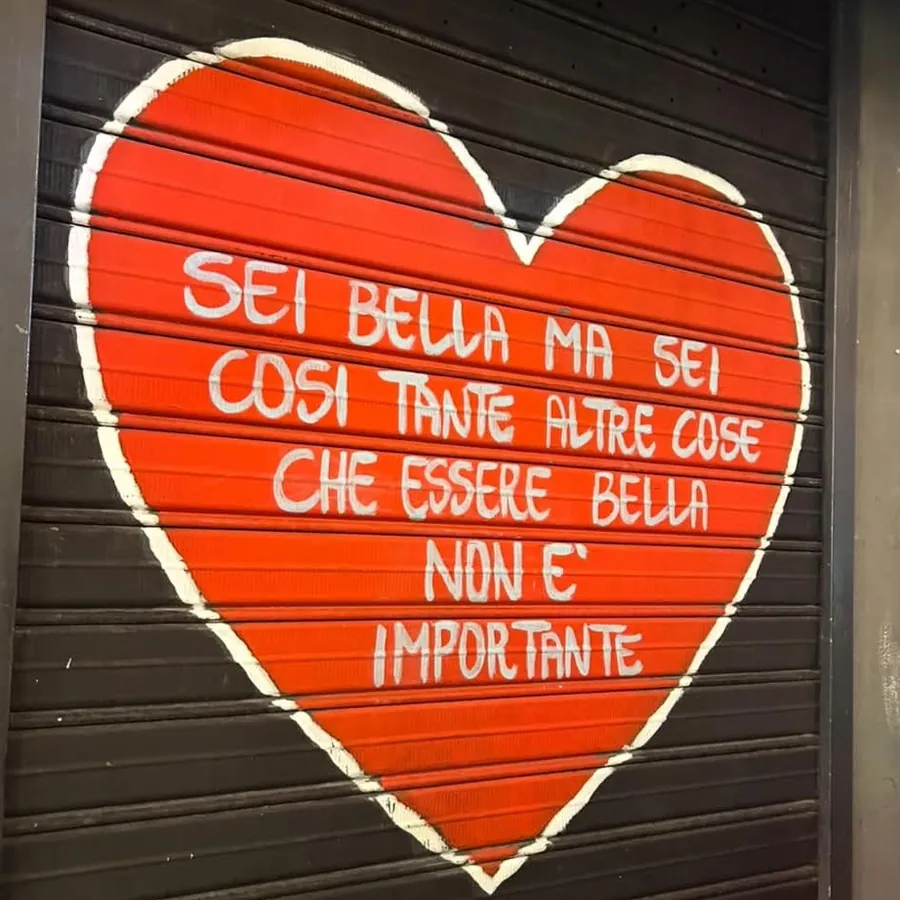 Un cœur rouge peint sur le volet, avec cette phrase en italien : tu es belle, mais tu es tellement d'autres choses qu'être belle n'a pas d'importance