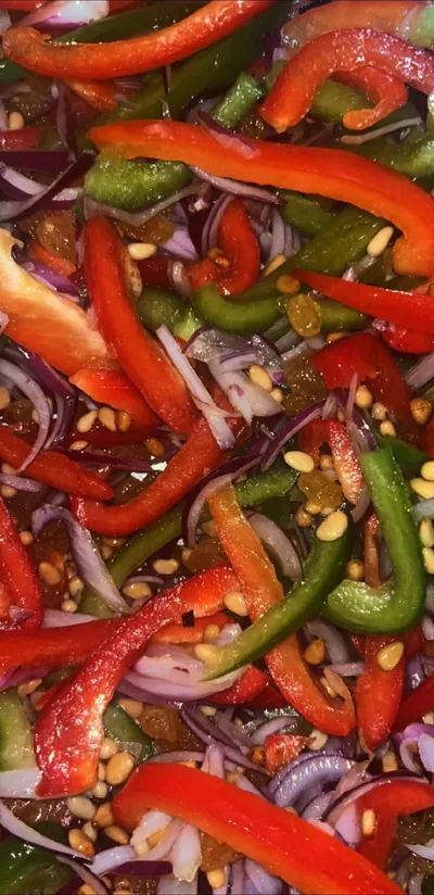 Poivrons rouges et verts en lanières, oignons rouges, raisins secs et pignons de pin